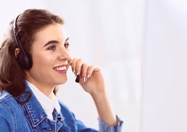 Retrato de una hermosa mujer de negocios trabajando en su escritorio con auriculares y portátil — Foto de Stock