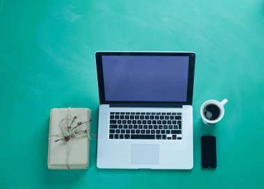 Ofis masasında dizüstü bilgisayarı ve bir sürü şeyi vardı.