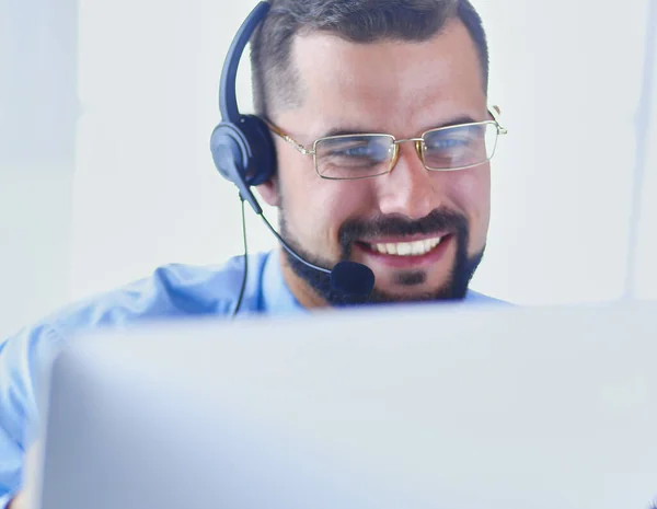 Felice uomo d'affari con auricolare seduto alla scrivania in ufficio moderno — Foto Stock