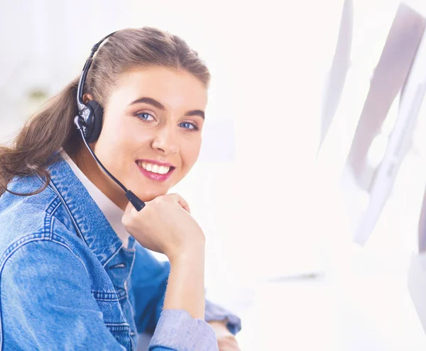 Porträtt av vacker affärskvinna som arbetar vid sitt skrivbord med headset och laptop — Stockfoto