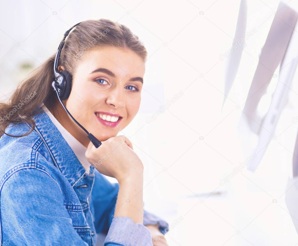 Portrait of beautiful business woman working at her desk with headset and laptop