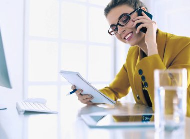 Güzel bir kadının portresi, iş yerinde dizüstü bilgisayarının önünde otururken ve yeni bir proje üzerinde çalışırken arama yapıyor.