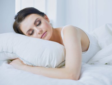 Genç ve güzel bir kadın yatakta yatıyor..