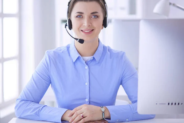 Grave bella giovane donna che lavora come operatore telefonico di supporto con auricolare in ufficio — Foto Stock