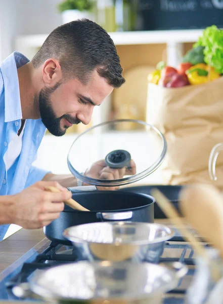 Muž po recept na digitální tablet a vaření chutné a zdravé jídlo v kuchyni doma — Stock fotografie
