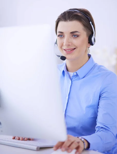 Mujer bastante joven y seria que trabaja como operador de telefonía de apoyo con auriculares en la oficina — Foto de Stock