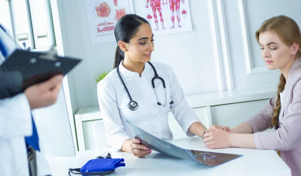 Kvinnlig läkare som ger en konsultation till en patient och förklarar medicinsk information och diagnos — Stockfoto