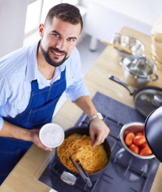 Adam ev mutfağında lezzetli ve sağlıklı yemekler hazırlıyor.