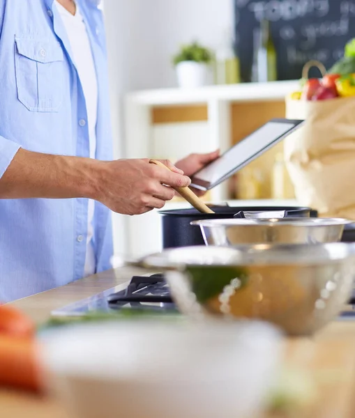 Mann folgt Rezept auf digitalem Tablet und kocht leckeres und gesundes Essen in der heimischen Küche — Stockfoto