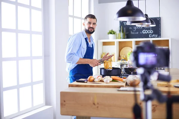 Man holding paper bag full of groceries on the kitchen background. Shopping and healthy food concept — Stock Photo, Image