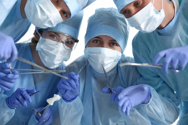 Níže pohled na chirurgy držící lékařské nástroje v rukou — Stock fotografie