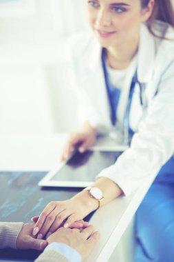 Kadın doktor bir hastaya danışmanlık yapıyor ve tıbbi bilgi ve teşhisi açıklıyor.