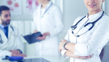 Steteskoplu kadın doktor kolları bağlı duruyor.