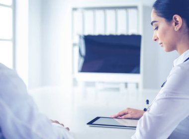 Başarılı tıp doktorları konferans boyunca belgeleri tartışıyor ve gülümsüyor.