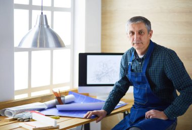 Ofisteki çizim masasında çalışan mimar