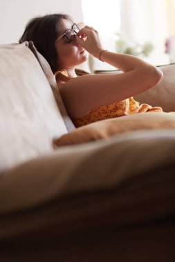 Evdeki modern bir kanepede oturan rahat kadın.