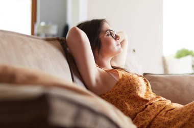 Evdeki modern bir kanepede oturan rahat kadın.