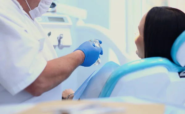 Odontólogos masculinos examinando y trabajando en mujeres jóvenes pacientes.Dentistas oficina. —  Fotos de Stock