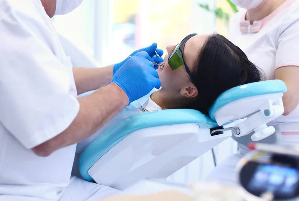 Homem dentista trabalhando em seus pacientes dentes — Fotografia de Stock