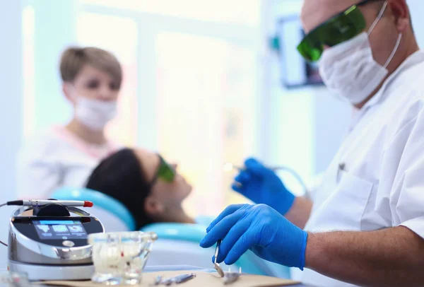 Hombre dentista trabajando en sus pacientes dientes — Foto de Stock