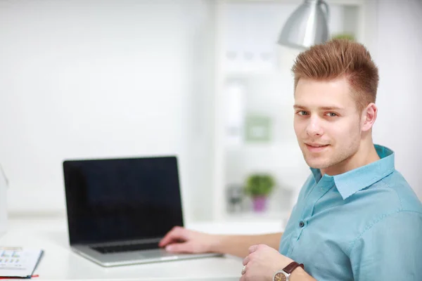 Ung man eller affärsman på ett skrivbord, isolerad på vit bakgrund — Stockfoto