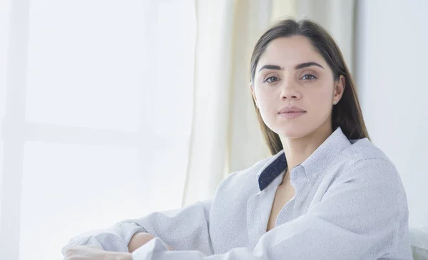 Portrait of woman using tablet and drinking coffee while sitting on the bed in the morning — Stock Photo, Image