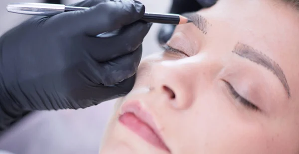 Cosmetologist applying permanent make up on eyebrows — Stock Photo, Image