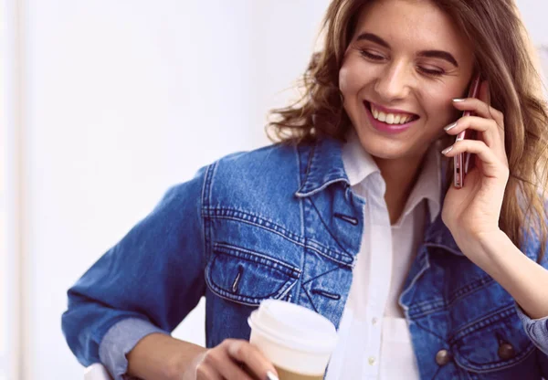 Junge Frau im Café trinkt Kaffee und telefoniert — Stockfoto