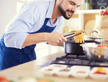 Adam ev mutfağında lezzetli ve sağlıklı yemekler hazırlıyor.