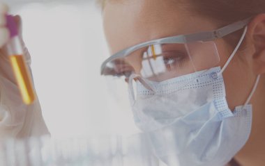 Modern laboratuvar veya hastanede plastik tıbbi tüplerle çalışan araştırmacı, doktor, bilim adamı veya laboratuvar asistanı