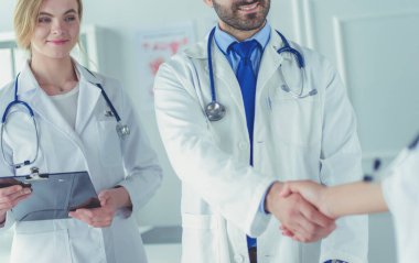 Bayan bir doktor başka bir doktora ofisinde röntgen gösteriyor.