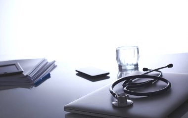 Dizüstü bilgisayarı, steteskopu ve defteri olan bir doktorun çalışma yeri.