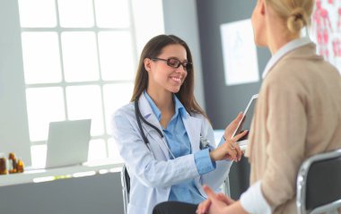 Doktor ve hasta masada otururken bir şey tartışıyorlar. İlaç ve sağlık hizmetleri kavramı