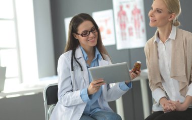 Doktor ve hasta masada otururken bir şey tartışıyorlar. İlaç ve sağlık hizmetleri kavramı