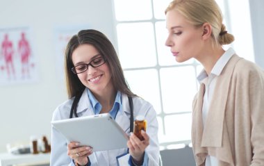 Doktor ve hasta masada otururken bir şey tartışıyorlar. İlaç ve sağlık hizmetleri kavramı