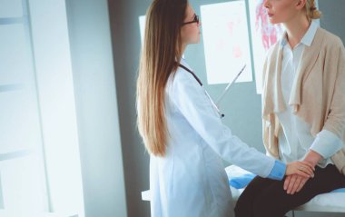 Doktor ve hasta masada otururken bir şey tartışıyorlar. İlaç ve sağlık hizmetleri kavramı