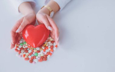 Masada kırmızı kalbi ve steteskopu olan kardiyolog.