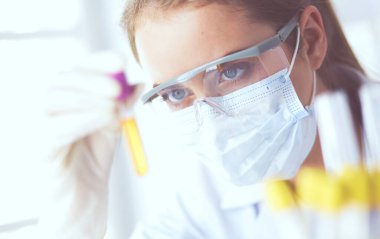 Modern laboratuvar veya hastanede plastik tıbbi tüplerle çalışan araştırmacı, doktor, bilim adamı veya laboratuvar asistanı