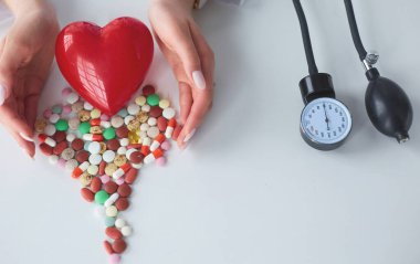 Masada kırmızı kalbi ve steteskopu olan kardiyolog.