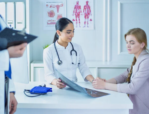 Kvinnlig läkare som ger en konsultation till en patient och förklarar medicinsk information och diagnos — Stockfoto