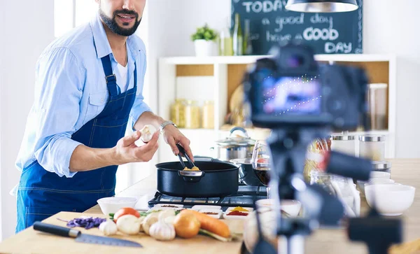 Man met papieren zak vol boodschappen op de keukenachtergrond. Winkelen en gezond voedsel concept — Stockfoto