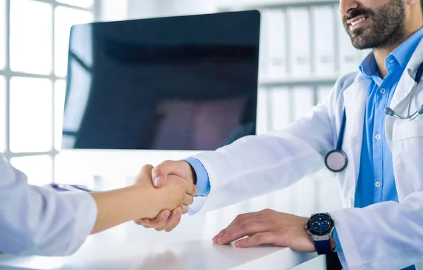 Medico che stringe la mano al paziente in ufficio alla scrivania — Foto Stock