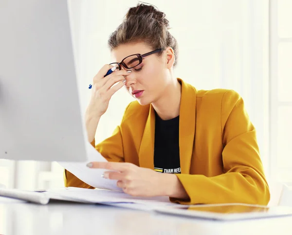 Retrato de una joven mujer de negocios cansada usando laptop y trabajando — Foto de Stock