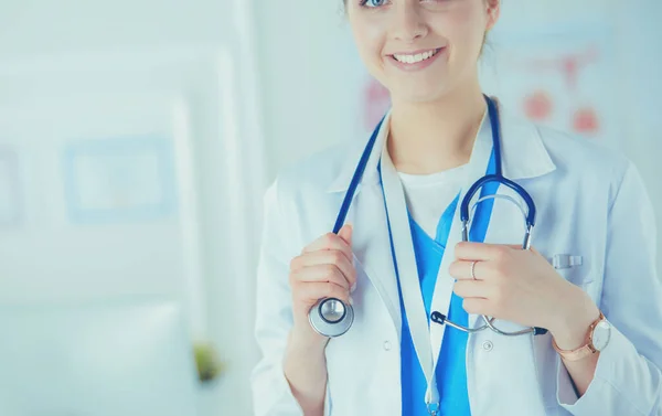 Portrait of young woman doctor with white coat standing in hospital — Stok Foto