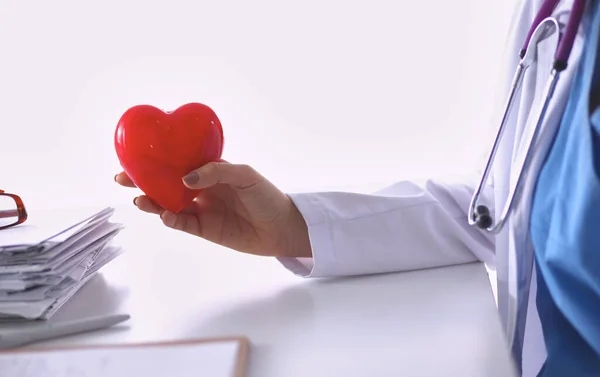 Jovem médico com símbolo de coração vermelho sentado na mesa — Fotografia de Stock
