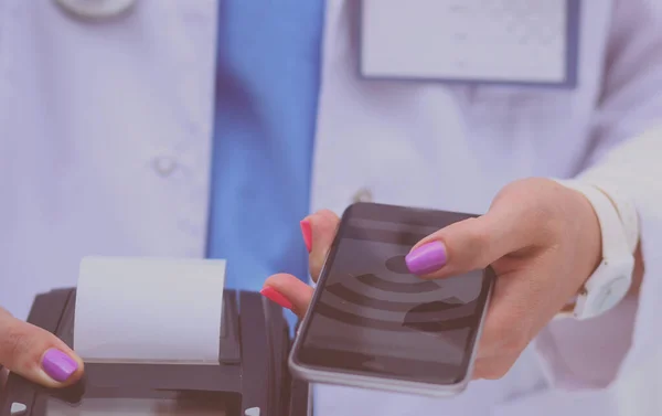 De dokter houdt de betaalterminal in handen. Betalen voor de gezondheidszorg. Dokter. — Stockfoto