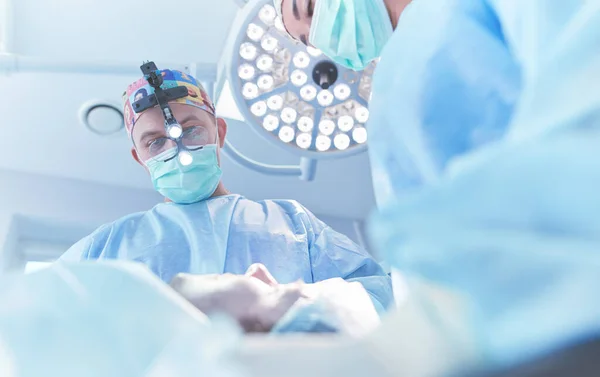 Homem cirurgião no trabalho na sala de cirurgia — Fotografia de Stock