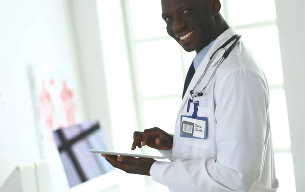 Trabajador médico negro masculino con tableta de pie en el hospital — Foto de Stock