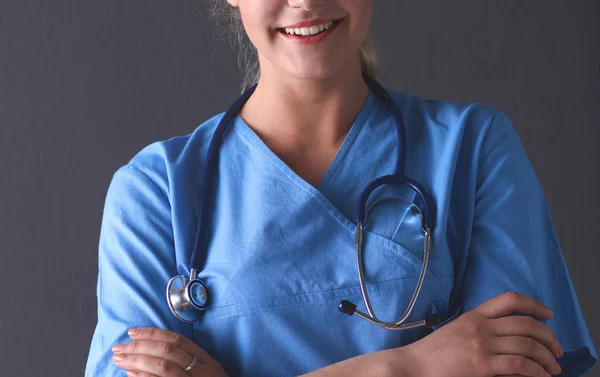 Fiatal orvos nő sztetoszkóppal elszigetelt szürke háttér — Stock Fotó