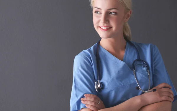 Ung läkare kvinna med stetoskop isolerad på grå bakgrund — Stockfoto
